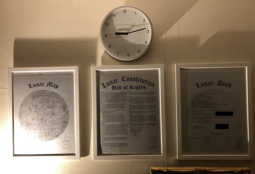部屋の壁に飾った月の土地の権利書をライトアップしたもの